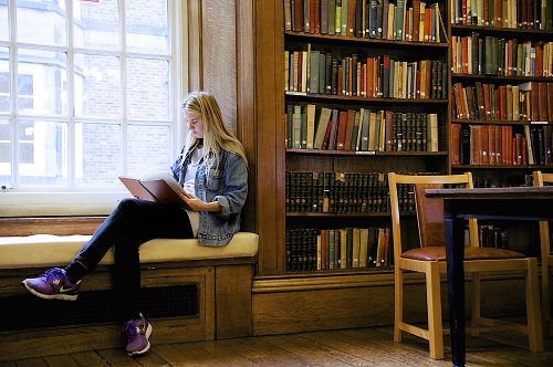 Girl sitting and reading in the library